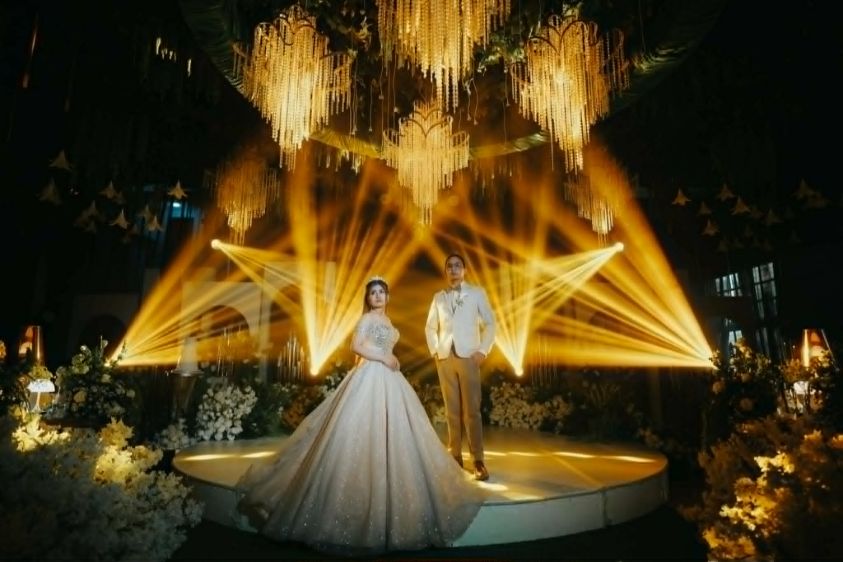 Couple on a round stage with golden beams